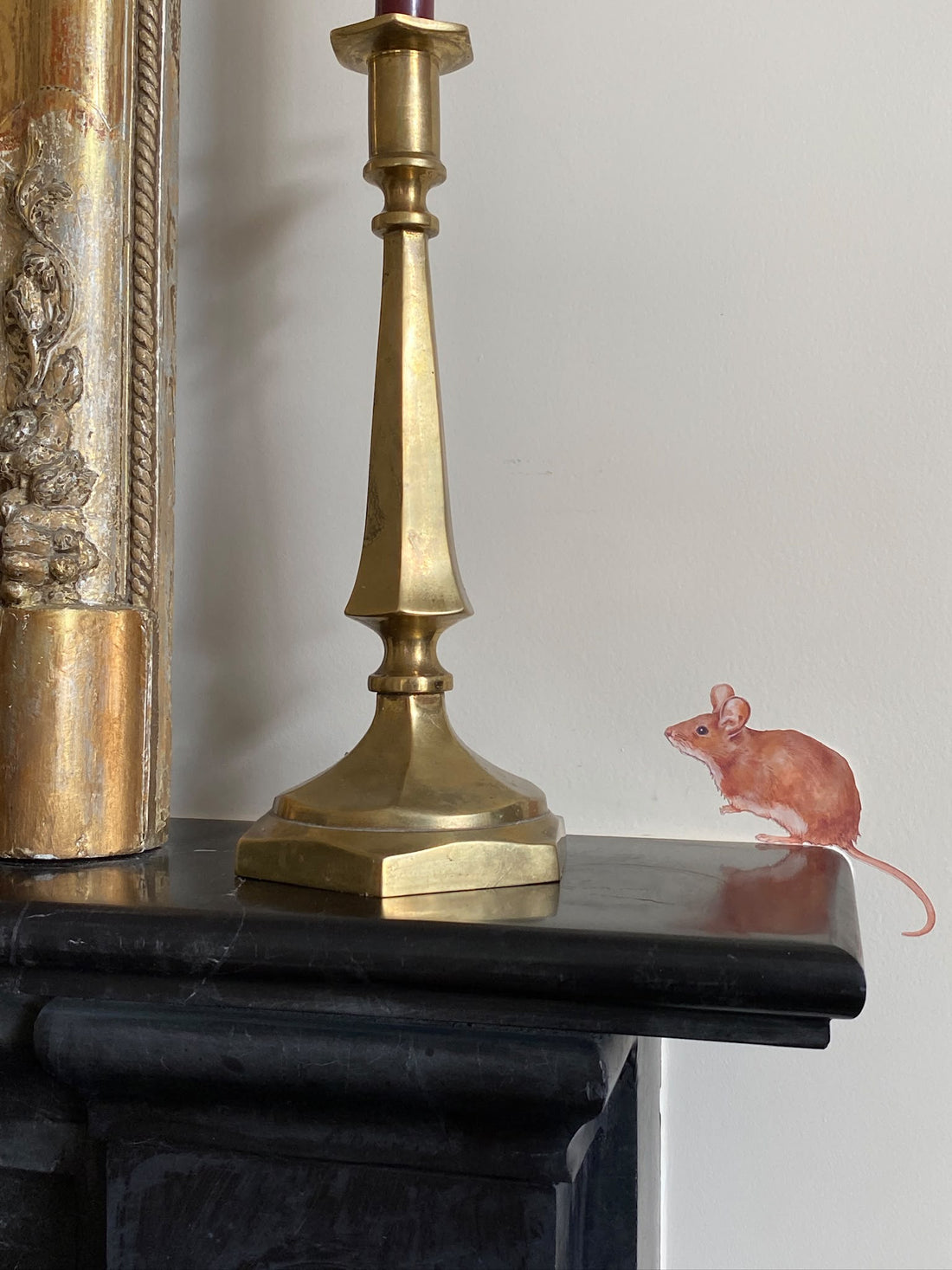 Hand-painted field mouse wall decal on a mantelpiece, a whimsical peel-and-stick touch for a living room or fireplace